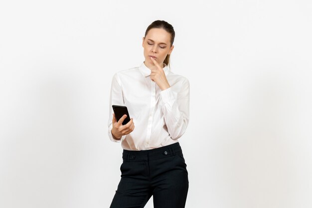 Trabajadora en elegante blusa blanca con teléfono en blanco