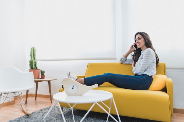 Foto gratuita trabajadora joven descansando y hablando por teléfono