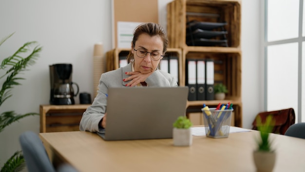 Foto gratuita trabajadora de negocios hispana de mediana edad que trabaja en la oficina