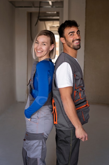 Trabajadores de la construcción sonrientes de tiro medio