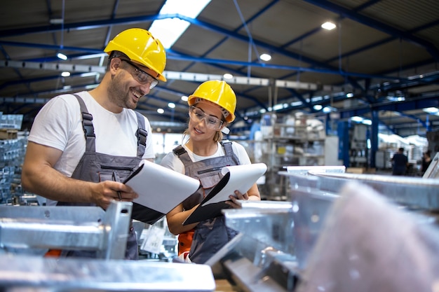 Trabajadores de la fábrica analizando los resultados de producción en una gran nave industrial