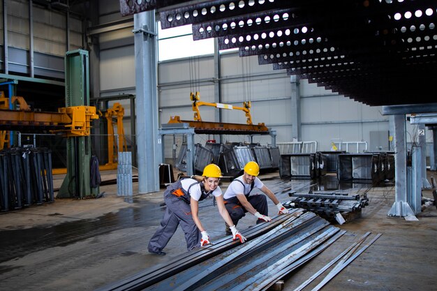 Trabajadores de la fábrica que manipulan piezas metálicas juntos