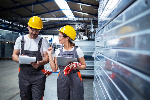 Trabajadores de la fábrica trabajando juntos en la sala de producción industrial