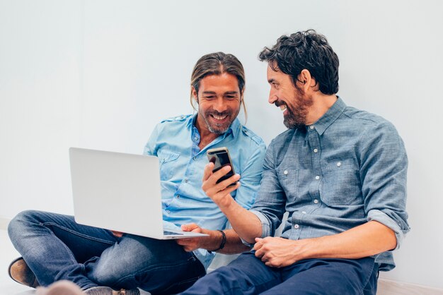 Trabajadores felices con portátil y teléfono móvil