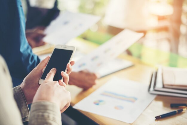 Trabajadores con gráficos y teléfonos