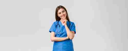Foto gratuita trabajadores médicos cuidado de la salud covid19 y concepto de vacunación optimista sonriente bonita enfermera doctora en batas azules clínica de trabajo mirando con una cámara de mirada entusiasta escuchando a un compañero de trabajo