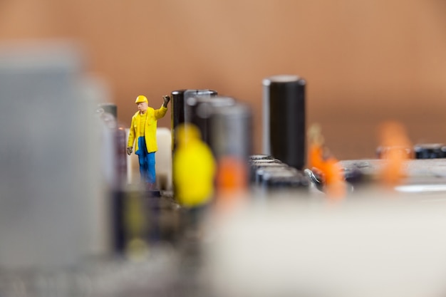 Foto gratuita trabajadores miniatura que trabajan en el chip de la placa base