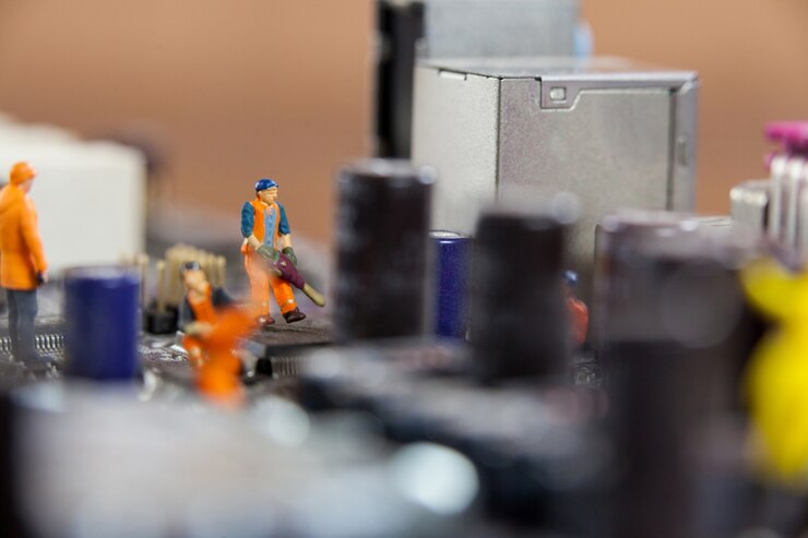 Foto gratuito trabajadores miniatura que trabajan en el chip de la placa base