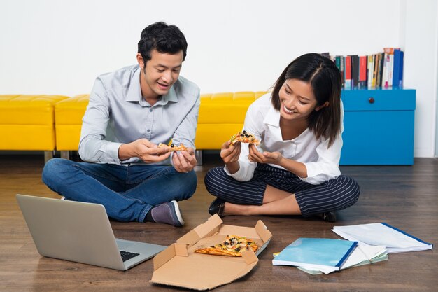 trabajadores de la oficina de Asia feliz comiendo pizza en la oficina