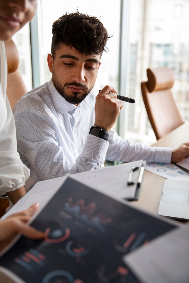 Foto gratuito trabajadores de oficina que utilizan gráficos financieros