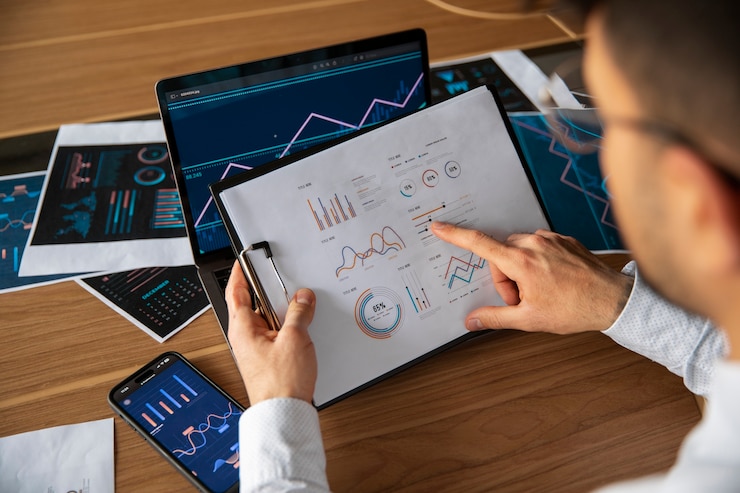 Foto gratuito trabajadores de oficina que utilizan gráficos financieros