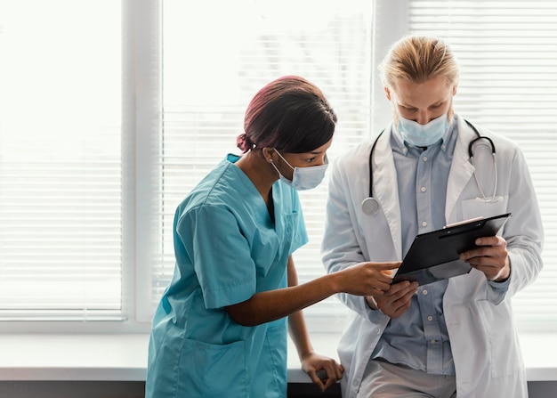 Trabajadores de la salud de tiro medio con máscaras