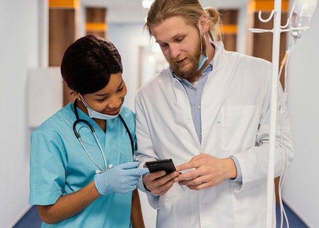 Trabajadores de la salud de tiro medio con smartphone