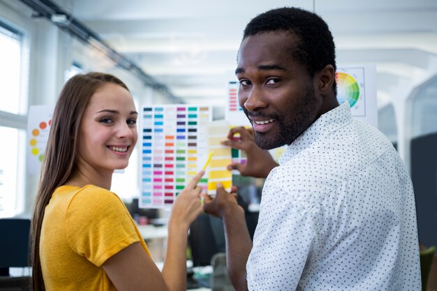 Trabajadores sonrientes mirando gamas de colores