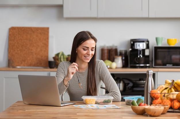 Foto gratuita trabajando desde la cocina y comiendo