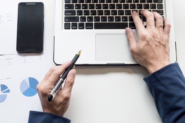 Trabajando en la computadora portátil, cerca de las manos del hombre de negocios.