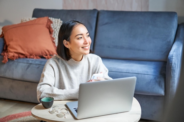 Foto gratuita trabajo desde casa freelance y concepto de elearning mujer joven estudiando sentada frente a la computadora portátil worki