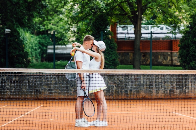 Trabajo en equipo. Una mujer hermosa y un hombre guapo después están jugando al tenis.