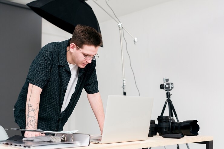 Foto gratuito trabajo fotógrafo hombre parado y mirando portátil