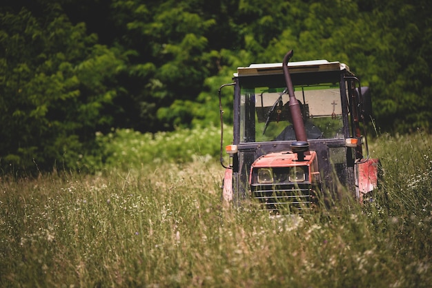 Tractor industrial cortando hierba en un campo