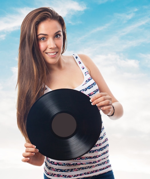 Foto gratuita traducir  mujer sonriendo con un disco de vinilo