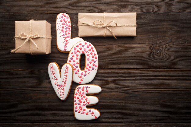 Traducir  palabra "love" con regalos marrones sobre una mesa de madera