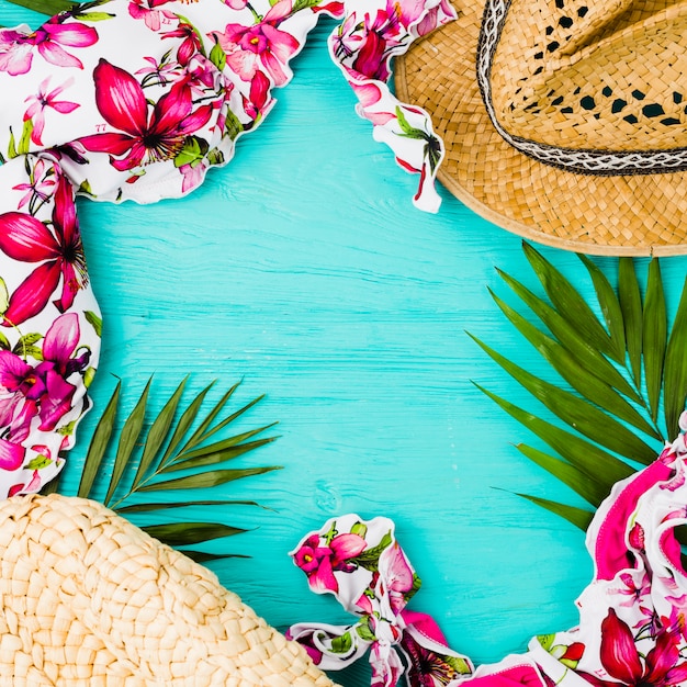 Traje de baño cerca de hojas de planta y sombrero.