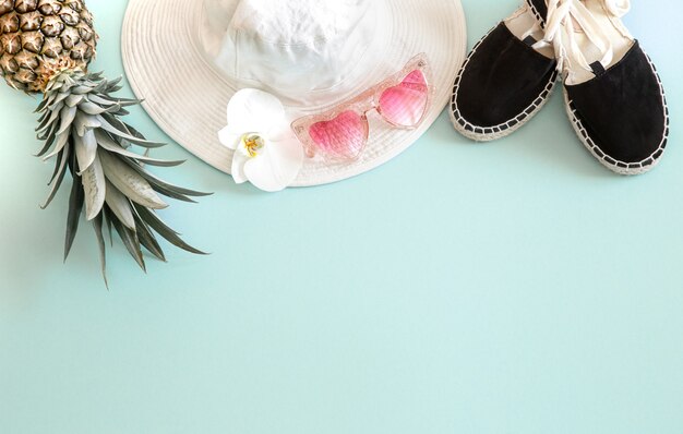 Traje de moda femenina de verano colorido plano. Sombrero de mujer elegante blanco con gafas de sol y piña fresca. Moda de verano o concepto de viaje de vacaciones.