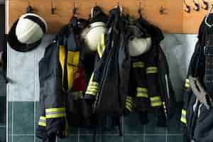 Foto gratuita trajes de bombero colgando de la pared en la estación