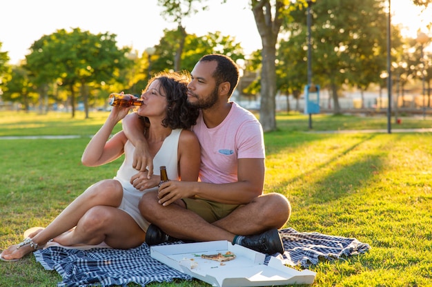 Tranquila pareja dulce disfrutando de una cena en el parque