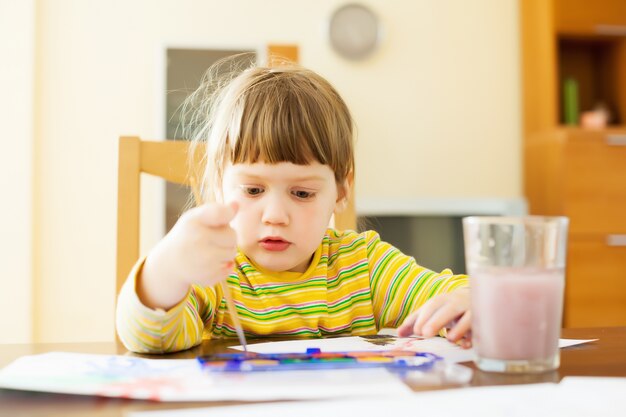tranquilo niño de dos años pintando con acuarela