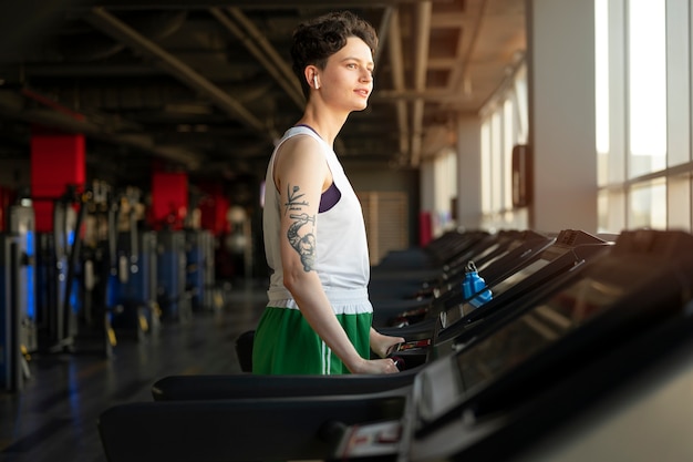 Foto gratuita trans hombre haciendo ejercicio en el gimnasio