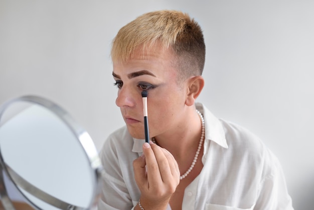 Transgénero de cerca con pincel de maquillaje