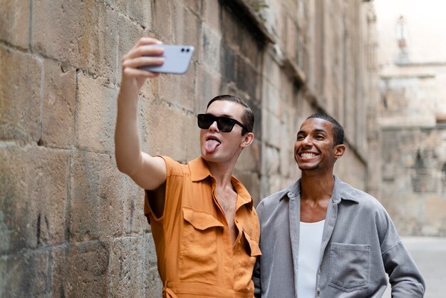 Transgénero de plano medio tomando selfie juntos