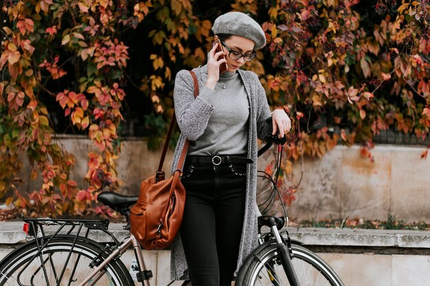 Transporte alternativo de bicicletas y mujer hablando por teléfono