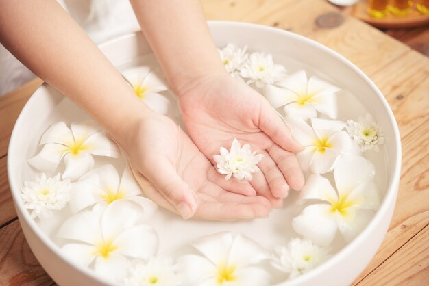 Tratamiento y producto de spa. flores blancas en cuenco de cerámica con agua para aromaterapia en el spa.