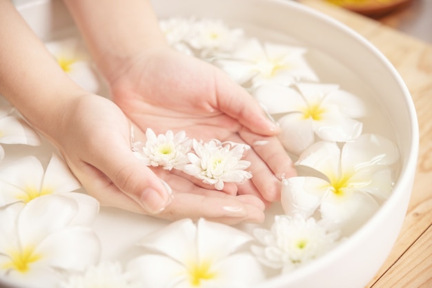 Foto gratuita tratamiento y producto de spa. flores blancas en cuenco de cerámica con agua para aromaterapia en el spa.