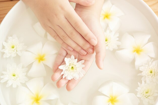 Tratamiento y producto de spa. flores blancas en cuenco de cerámica con agua para aromaterapia en el spa.