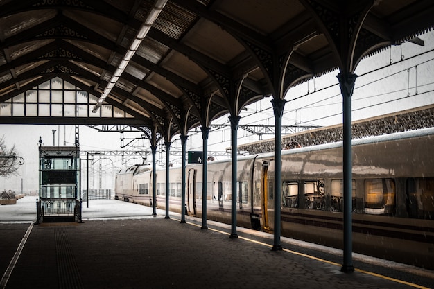 Tren en una estación de tren cubierta de nieve en invierno