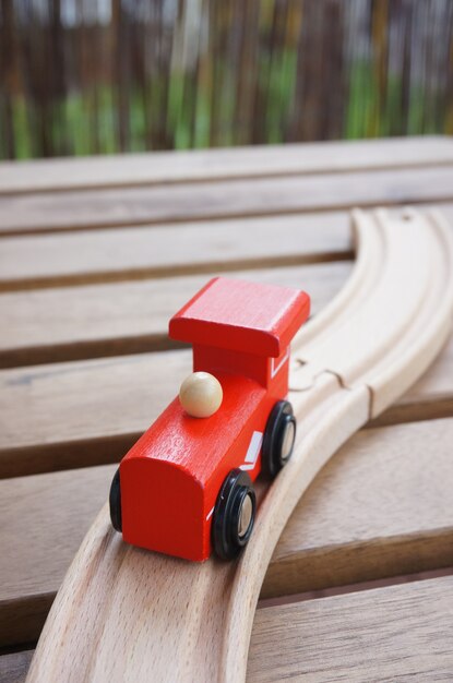 Tren de juguete rojo de madera sobre vías de madera