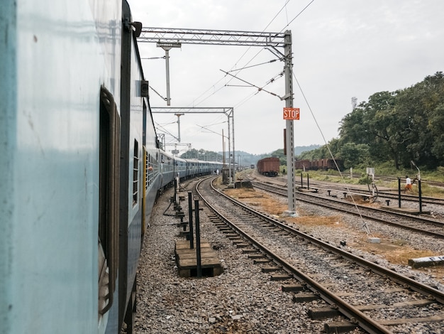 Tren que pasa en una estación de tren sobre un fondo de ferrocarril