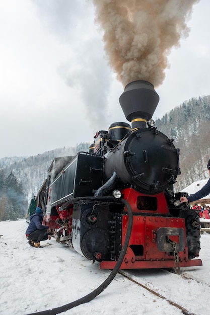 Tren de vapor mocanita en una estación de tren en invierno rumania