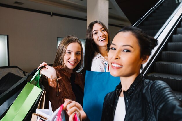 Trendy mujeres posando en la cámara mientras compra