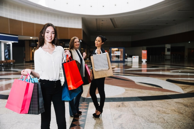 Trendy mujeres posando en el centro comercial juntos