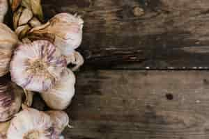 Foto gratuita trenza de bulbos de ajo sobre fondo de madera con textura