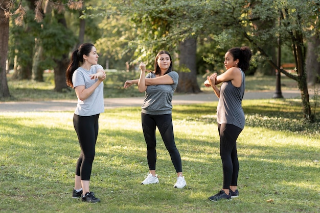 Foto gratuita tres amigas haciendo ejercicio en el parque