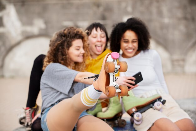 Tres amigas con patines tomando un selfie al aire libre