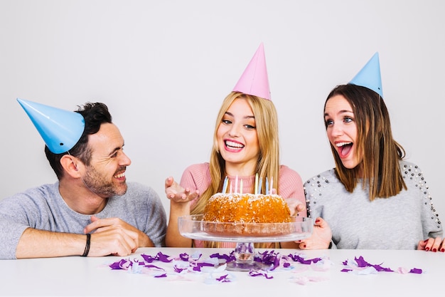 Tres amigos alegres celebrando cumpleaños