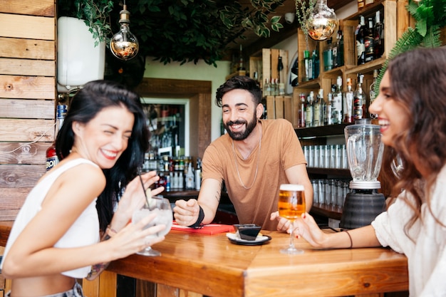 Foto gratuita tres amigos en bar riendo juntos