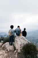 Foto gratuita tres amigos en la cima de la montaña mirando a la vista